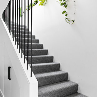 Idée de décoration pour un petit escalier nordique en L avec des marches en moquette, des contremarches en moquette et un garde-corps en métal.