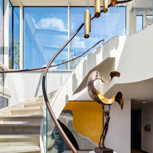 Inspiration for a contemporary curved mixed railing staircase in London.