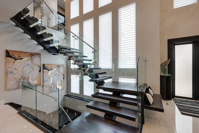Inspiration for a huge modern wooden floating glass railing staircase remodel in Edmonton