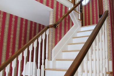 Example of a mid-sized classic wooden l-shaped staircase design in New York with painted risers