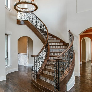 Photo of a mediterranean wood curved metal railing staircase in Dallas with tiled risers.