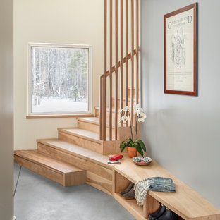 Esempio di una piccola scala curva design con pedata in legno, alzata in legno e parapetto in legno