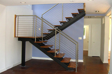 This is an example of a small traditional wood u-shaped staircase in Other with metal risers and feature lighting.