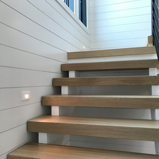Diseño de escalera en L y machihembrado, de tamaño medio, sin contrahuella, con escalones de madera, barandilla de metal y machihembrado