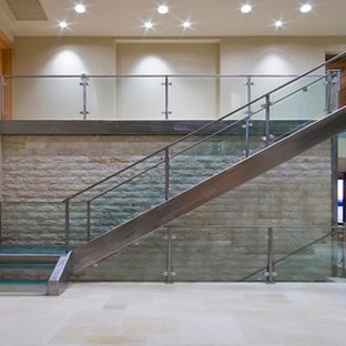 Immagine di una grande scala a "L" contemporanea con pedata in vetro e alzata in metallo
