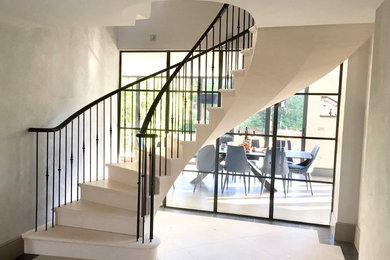 Пример оригинального дизайна: изогнутая лестница среднего размера в современном стиле с ступенями из известняка и подступенками из известняка