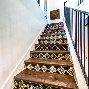 Idée de décoration pour un petit escalier sud-ouest américain en L avec des contremarches en carrelage, des marches en bois et un garde-corps en métal.