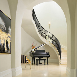Idées déco pour un très grand escalier courbe méditerranéen avec un garde-corps en métal, des marches en pierre calcaire et des contremarches en pierre calcaire.