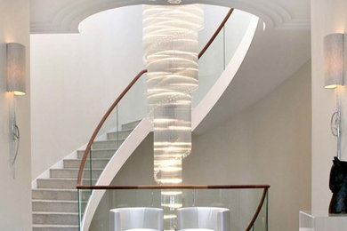 Design ideas for a contemporary concrete curved staircase in London with concrete risers and feature lighting.