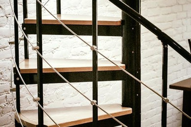 Ejemplo de escalera de caracol contemporánea de tamaño medio con escalones de madera, contrahuellas de metal y barandilla de metal