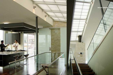 Foto de escalera recta moderna grande con escalones de madera, contrahuellas de madera y barandilla de metal