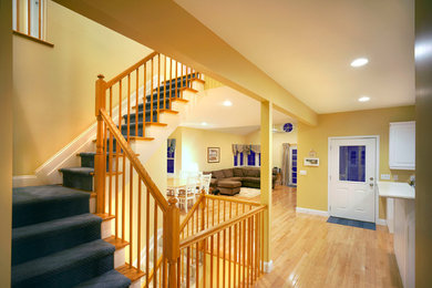 ニューアークにある高級な中くらいなトラディショナルスタイルのおしゃれなかね折れ階段 (カーペット張りの蹴込み板、木材の手すり) の写真