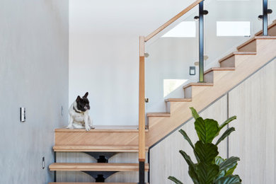 Идея дизайна: угловая лестница в современном стиле с деревянными ступенями и перилами из смешанных материалов без подступенок
