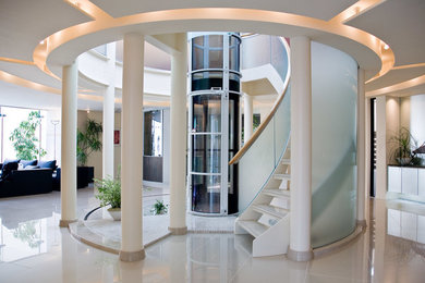 バンクーバーにあるお手頃価格の広いコンテンポラリースタイルのおしゃれな階段 (ガラスフェンス) の写真