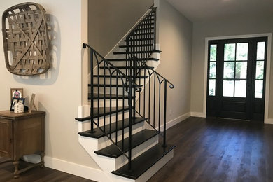 Imagen de escalera en L industrial de tamaño medio con escalones de madera pintada y barandilla de metal