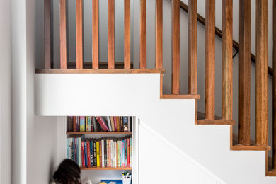 Modelo de escalera en U contemporánea de tamaño medio con escalones de madera, contrahuellas de madera y barandilla de madera