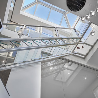 Idee per una grande scala a rampa dritta minimalista con pedata in vetro e nessuna alzata