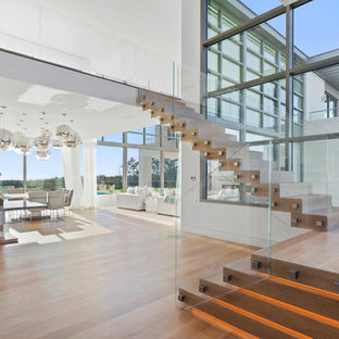 Staircase - large contemporary wooden l-shaped glass railing staircase idea in New York with wooden risers