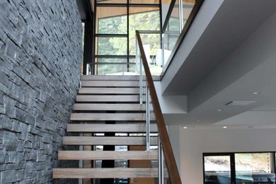 Staircase - mid-sized modern wooden l-shaped glass railing staircase idea in Calgary with wooden risers