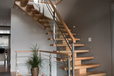 Foto de escalera curva actual de tamaño medio sin contrahuella con escalones de madera