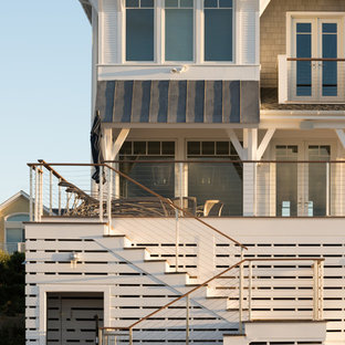 Example of a mid-sized beach style wooden u-shaped cable railing staircase design in New York with wooden risers