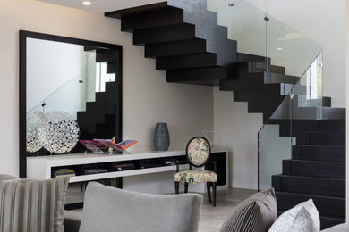 Foto de escalera minimalista con escalones de madera, contrahuellas de madera y barandilla de vidrio