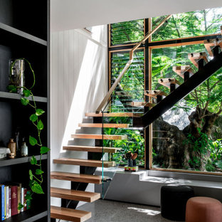 Mid-sized contemporary wood l-shaped staircase in Brisbane with glass railing and open risers.
