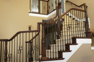 Ejemplo de escalera curva tradicional grande con escalones de madera, contrahuellas de madera y barandilla de varios materiales
