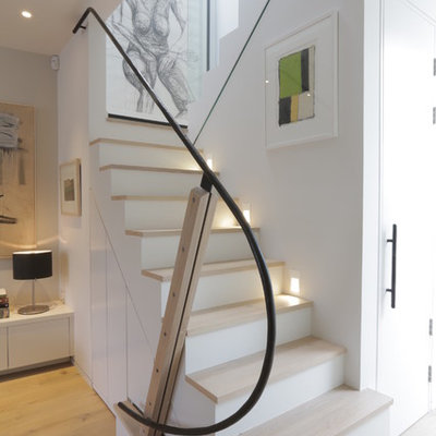 Inspiration for a mid-sized contemporary wooden u-shaped metal railing staircase remodel in London with painted risers