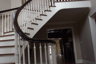 Staircase - large traditional wooden curved staircase idea in New York with wooden risers