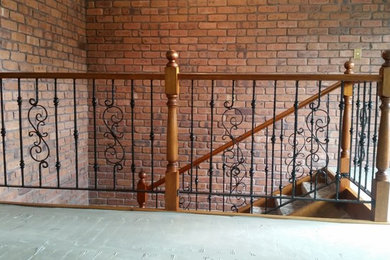 На фото: п-образная деревянная лестница в классическом стиле с деревянными ступенями и металлическими перилами с