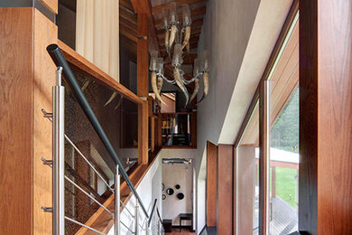 На фото: большая прямая металлическая лестница в современном стиле с крашенными деревянными ступенями и металлическими перилами с