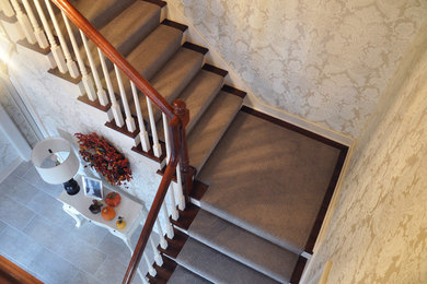 Ejemplo de escalera en L actual de tamaño medio con escalones de madera y contrahuellas de madera pintada