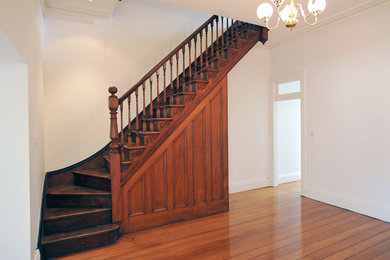 Idée de décoration pour un escalier victorien en L avec des marches en bois et des contremarches en bois.