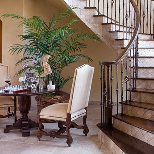 Foto de escalera curva, mediterránea, con escalones de madera, barandilla de madera y contrahuellas de travertino