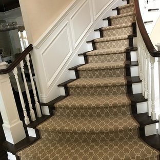 Ispirazione per una grande scala curva classica con pedata in legno, alzata in legno e parapetto in legno