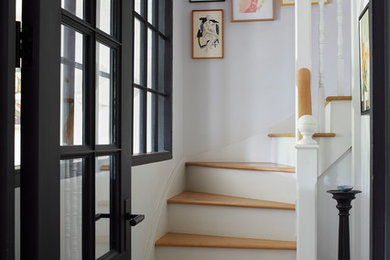 Mid-sized transitional wooden curved wood railing staircase photo in Devon with wooden risers