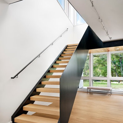 Inspiration for a large modern wooden curved open staircase remodel in Austin