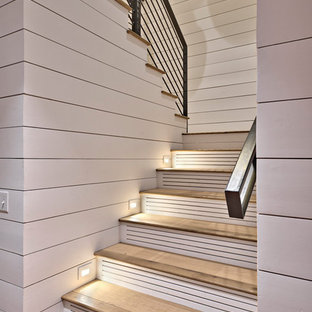 Immagine di una grande scala a "U" tradizionale con pedata in legno, alzata in legno verniciato e parapetto in metallo