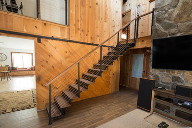 Ejemplo de escalera suspendida rural de tamaño medio con escalones de madera, contrahuellas de metal y barandilla de madera