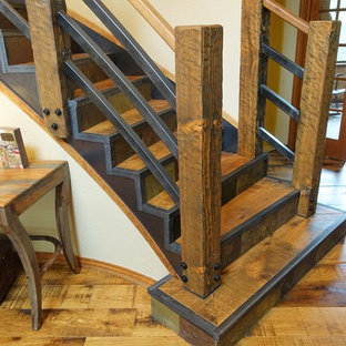 Exemple d'un grand escalier courbe montagne avec des marches en bois, des contremarches en ardoise et un garde-corps en bois.