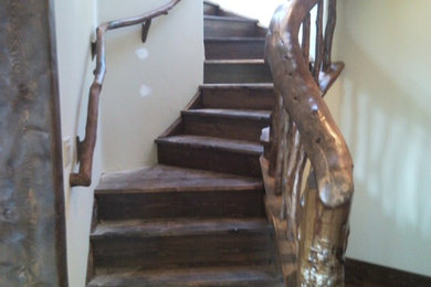 Ejemplo de escalera curva rural con escalones de madera y contrahuellas de madera