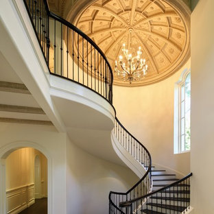 Example of a large ornate wooden spiral mixed material railing staircase design in Los Angeles with painted risers