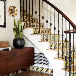 Modelo de escalera curva, mediterránea, con escalones de madera, contrahuellas con baldosas y/o azulejos y barandilla de varios materiales
