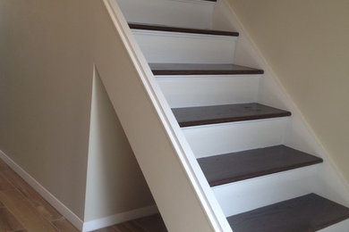 This is an example of a large contemporary wood straight staircase in New York with wood risers.