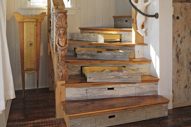 Foto de escalera curva marinera grande con escalones de madera, contrahuellas de madera y barandilla de madera