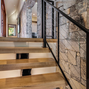 Foto di una grande scala a rampa dritta stile rurale con pedata in legno, nessuna alzata e parapetto in cavi