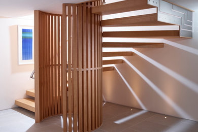 На фото: п-образная лестница в современном стиле с деревянными ступенями без подступенок с