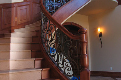 Inspiration for a large classic wood curved mixed railing staircase in Other with wood risers.