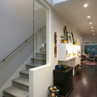 Example of a large trendy carpeted straight glass railing staircase design in Orange County with carpeted risers
